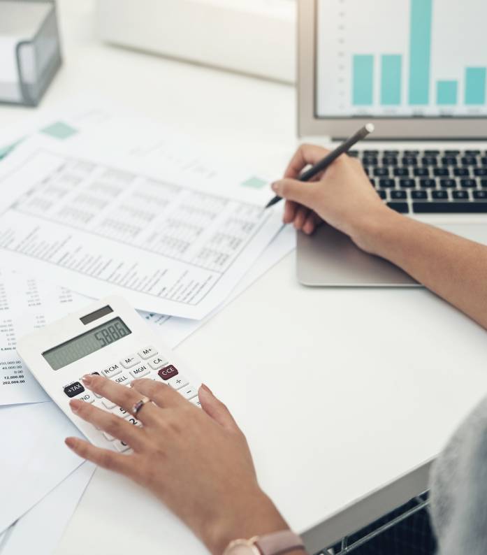 GettyImages-1330234567 Person calculating finances with laptop and documents.