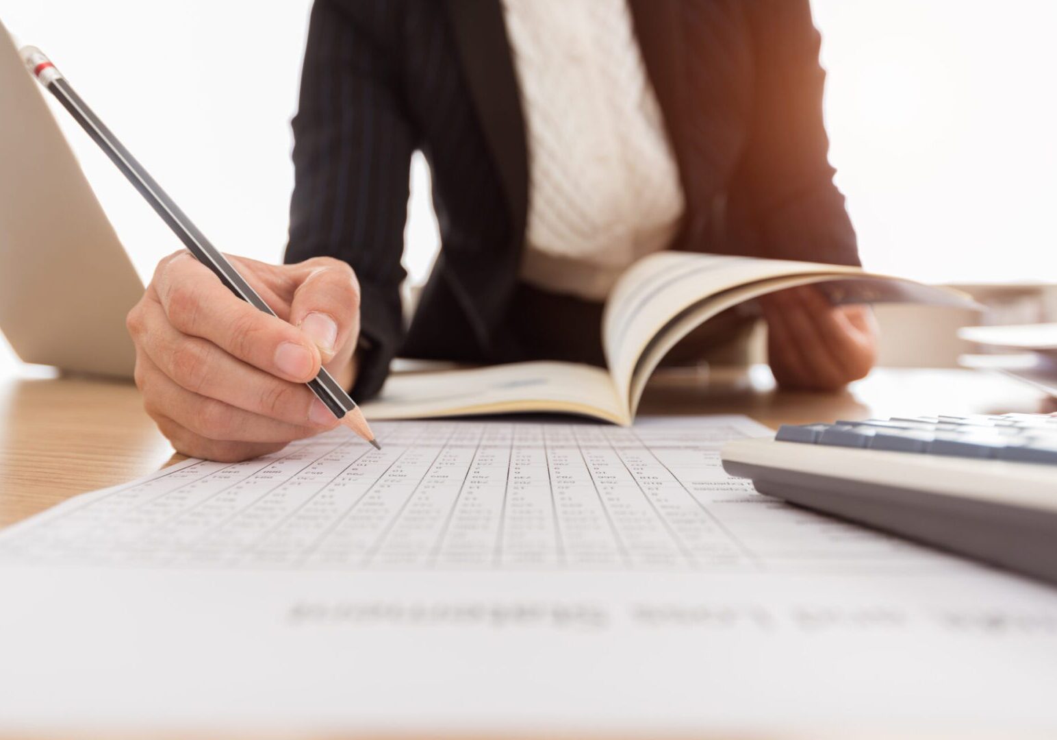 Person analyzing documents and taking notes.
